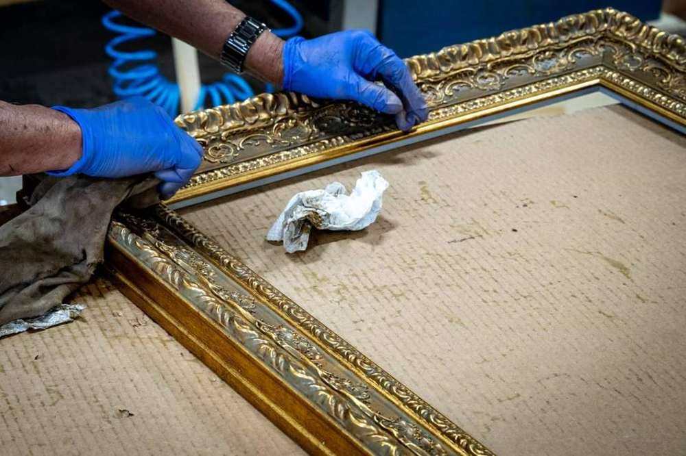 Hand finishing an ornate gold frame